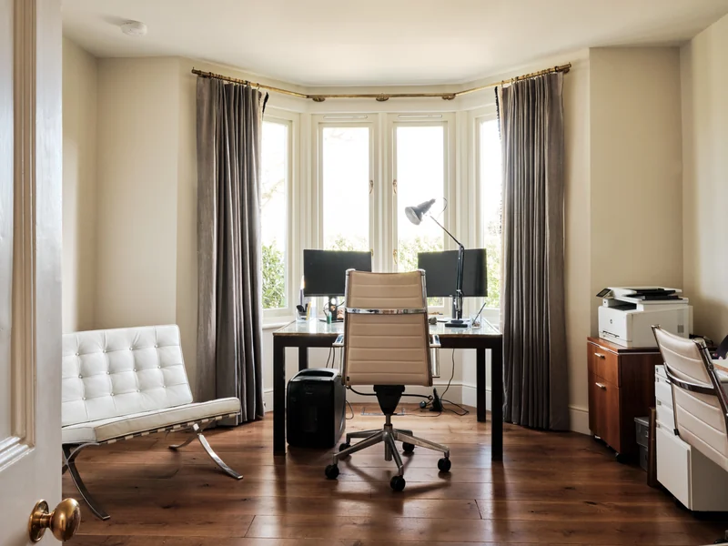 Study with a desk in the bay window and a reading chair