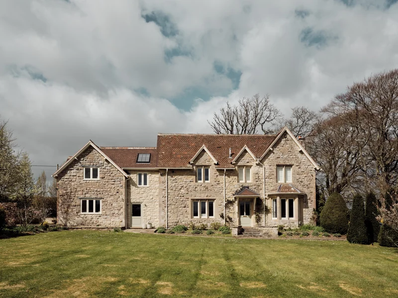 Stone facade of a country house viewed across the lawn