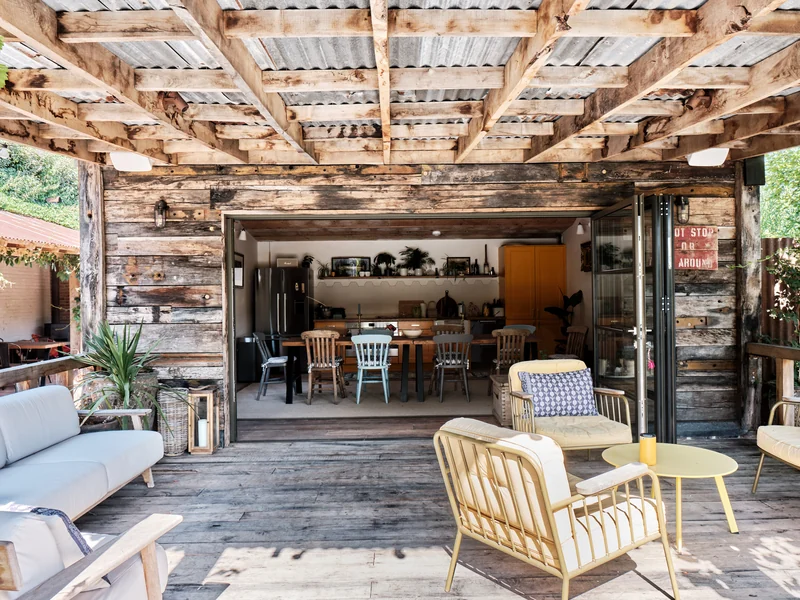 Covered timber entertaining space opening onto a dining room